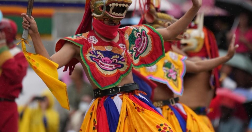 Masked dancers in brocade costumes at a Bhutanese festival